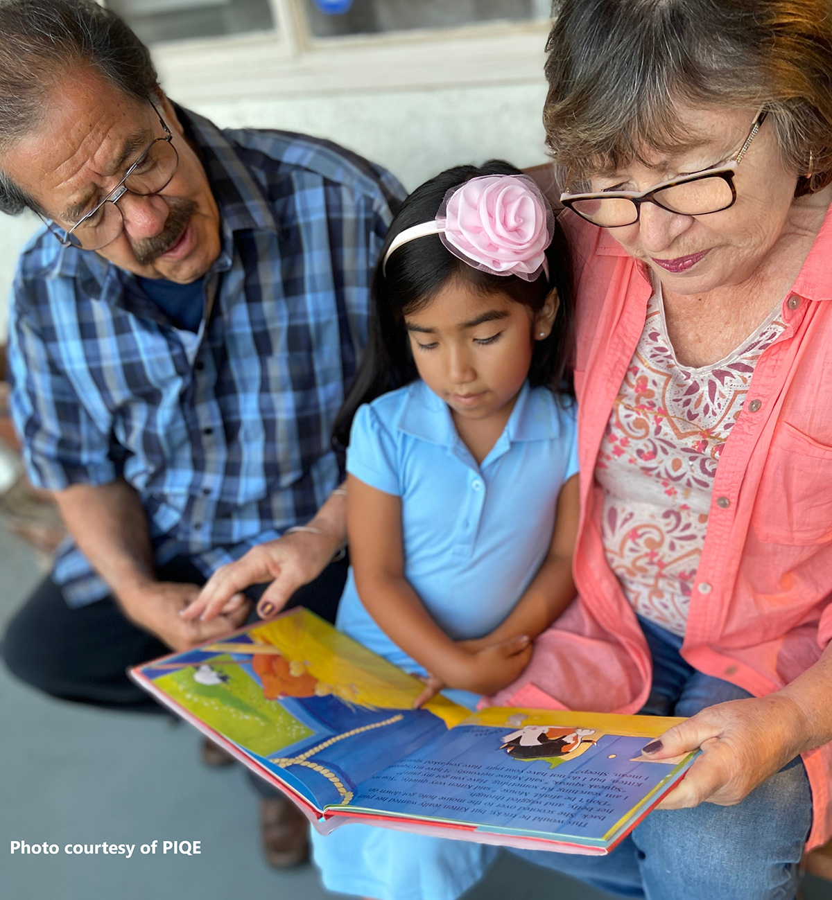 Grandparents reading with their grandchild